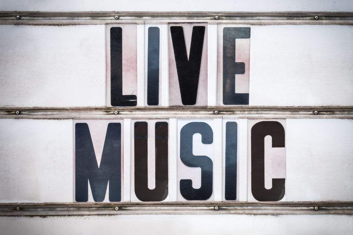 A white marquee sign with bold black letters that spell out "LIVE MUSIC."